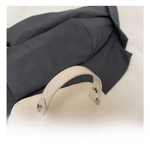 Close-up of cream box handbag showing comfortable handle and silver metal hardware details
