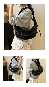 Détail du sac croissant noir avec nœud décoratif et bandoulière nuage froncée