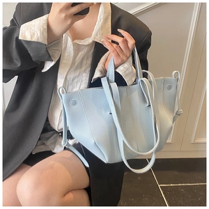Close-up of light blue lychee pattern leather tote bag with elegant silver side buckle