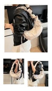 Détail d'un sac demi-lune blanc crème avec bandoulière plissée et décorations à nœuds