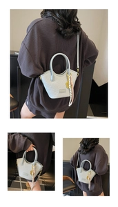 Détails de la texture tissée et des finitions dorées sur le sac seau bleu clair