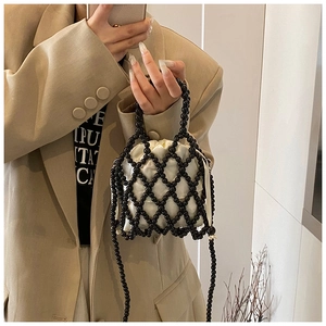 Détail du sac seau perlé avec maille noire tissée et doublure en satin crème à cordon