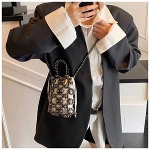 Detail der grauen Perltasche mit weißem Satin-Beutel und dünner Perlenkette für Damen