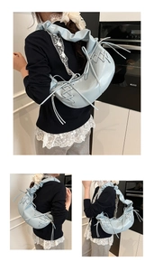 Détail du sac croissant bleu clair avec bandoulière plissée et rubans décoratifs latéraux