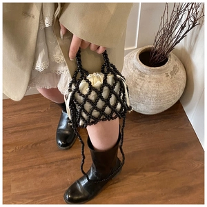 Détail du sac à main perlé avec doublure en satin et bandoulière tissée élégante