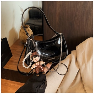 Detail of black patent leather bag with BAFANSHA logo, metallic chain, and pearl pendant