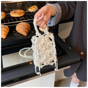 Detail der Perlen-Eimertasche mit weißem Satin-Kordelzugfutter in einer Bäckerei-Szenerie