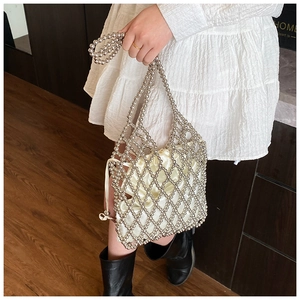 Détail du sac perlé argenté avec treillis métallique et doublure en satin crème à cordon