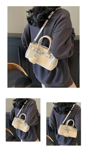Detailed close-up of a cream lychee-textured crossbody bag with silver hardware