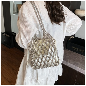 Détail du sac à perles argentées avec pochette en satin porté par un mannequin
