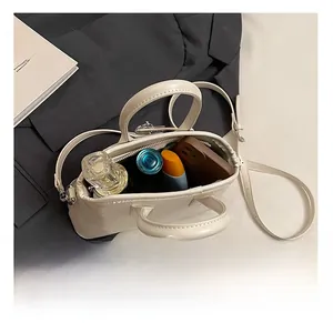 Top-down view of a cream-colored seashell bag showing internal storage for daily essentials