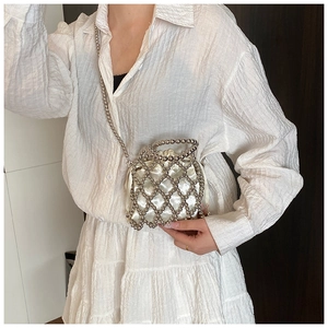 Détail du sac à main perlé argenté avec doublure en satin et bandoulière en métal