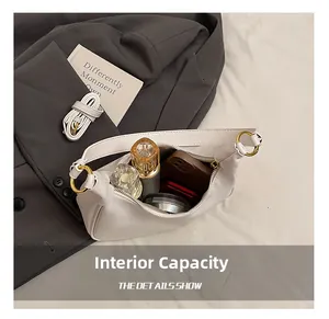 Internal capacity of the white faux leather tote showing phone and perfume inside