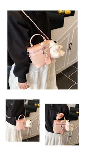 Pink quilted box bag with silver chain strap and white plush puppy charm detail