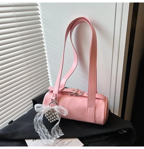 Pink glossy cylindrical baguette bag with white lace bow and silver heart pendant