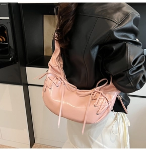Sac bandoulière rose plissé avec détails de laçage style corset porté à l'épaule