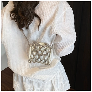 Détail d'un sac bandoulière en résille argentée avec pochette en satin ivoire