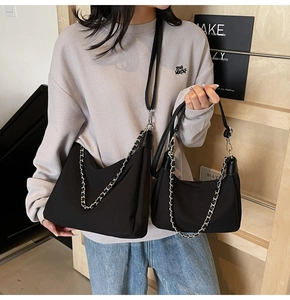 Detailansicht zweier schwarzer Nylon-Taschen mit Silberkette und Leder-Schulterriemen