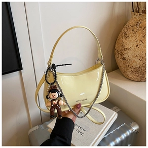 Light yellow patent leather shoulder bag with zipper and cute cartoon charm detail