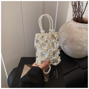 Detailansicht einer eleganten weißen Perlen-Webtasche mit einem Innenbeutel aus weißem Satin