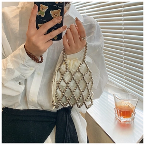 Détail d'un sac à perles métalliques fait main avec pochette intérieure à cordon beige