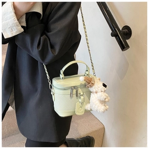 Detail of mint green crocodile embossed box bag with silver chain and cute dog charm