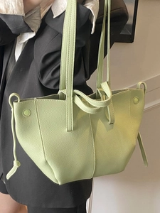 Minimalist light green lychee pattern leather tote bag shown on model with wide shoulder straps