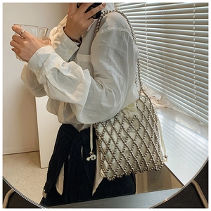 Gros plan d'un sac à main en résille argentée avec pochette intérieure blanche