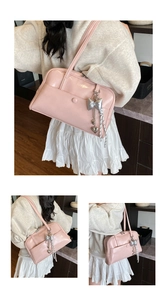 Detail view of pink patent leather shoulder bag with decorative silver bow and heart charms