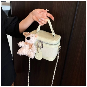 Detailed shot of mint green PU leather box bag with quilted pattern and bear charm