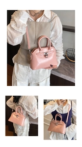 Detail view of pink oil wax leather shell bag showing silver lock and shiny finish