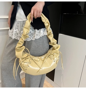 Détail du sac hobo jaune brillant avec poignée plissée et design à lacets croisés