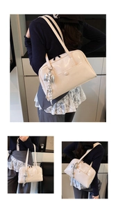 Detail of cream oil-wax leather Boston bag with silver bow pendant and snap pocket