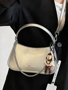 Chic silver patent leather crescent handbag with metal chain and cartoon charm accessory