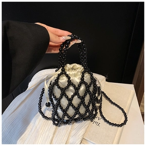 Détail du sac à main perlé avec filet noir et doublure en satin crème à cordon