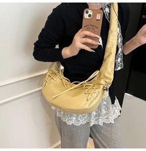 Détail du sac à main plissé jaune beurre avec laçage croisé porté par un mannequin