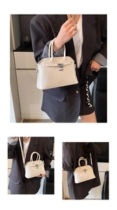 Detail of elegant cream shell handbag featuring silver metallic lock and shiny oil wax finish