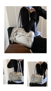 Close-up of metallic silver shoulder bag with heart charms and JK style details