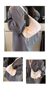 Detail of white oil wax leather crescent bag with gold hardware and tassel charm
