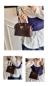 Detail of dark brown shell bag showing smooth faux leather texture and silver turn-lock