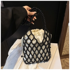 Vue détaillée d'un sac à perles noires avec une pochette intérieure en satin crème