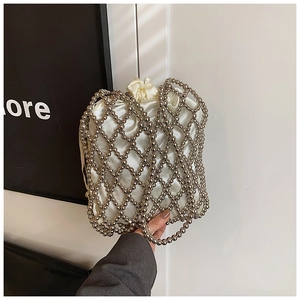 Détail du sac à perles argentées montrant le tissage en treillis et la pochette en satin