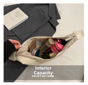 Detail view of beige crescent hobo bag interior showing spacious storage for essentials