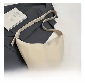 Macro detail of creamy white hobo bag with textured fabric and adjustable strap