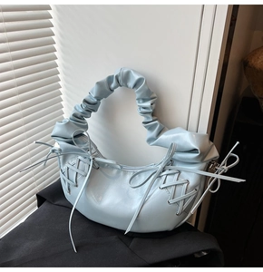 Détail du sac plissé bleu clair avec lanières croisées et nœuds de style balletcore