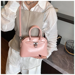 Detailed view of light pink oil wax leather shell bag with silver padlock and metal buckle