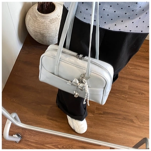 Detail of light blue oil wax leather Boston bag with silver bow and bear pendant accessory