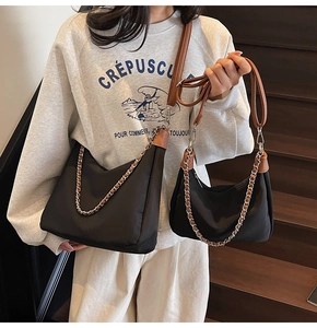 Detail von schwarzem Nylon-Hobo-Taschen-Set mit braunen Lederriemen und Kette