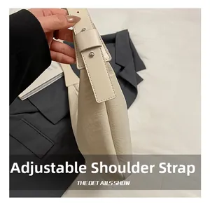 Detail shot of the adjustable shoulder strap on a beige pebbled leather hobo bag
