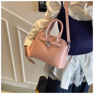 Pink oil-wax leather shell handbag with silver padlock detail shown on a model